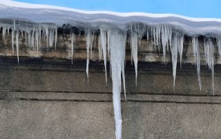icicles hanging down from snow covered roof