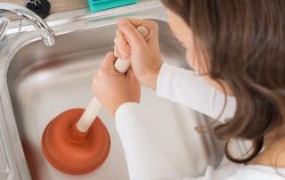 Woman plunging kitchen sink