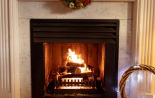Fireplace and mantel with wreath in the living room of a home